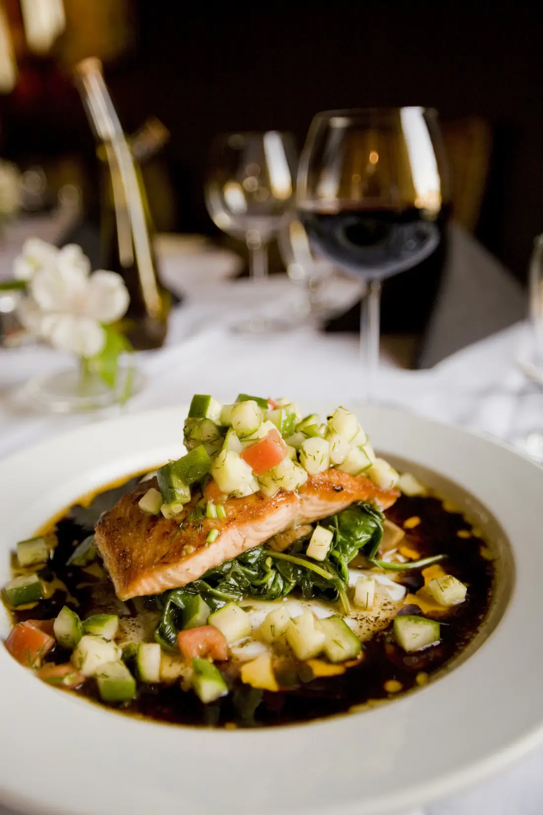 Lachsfilet mit Gemüse und einem Glas Rotwein